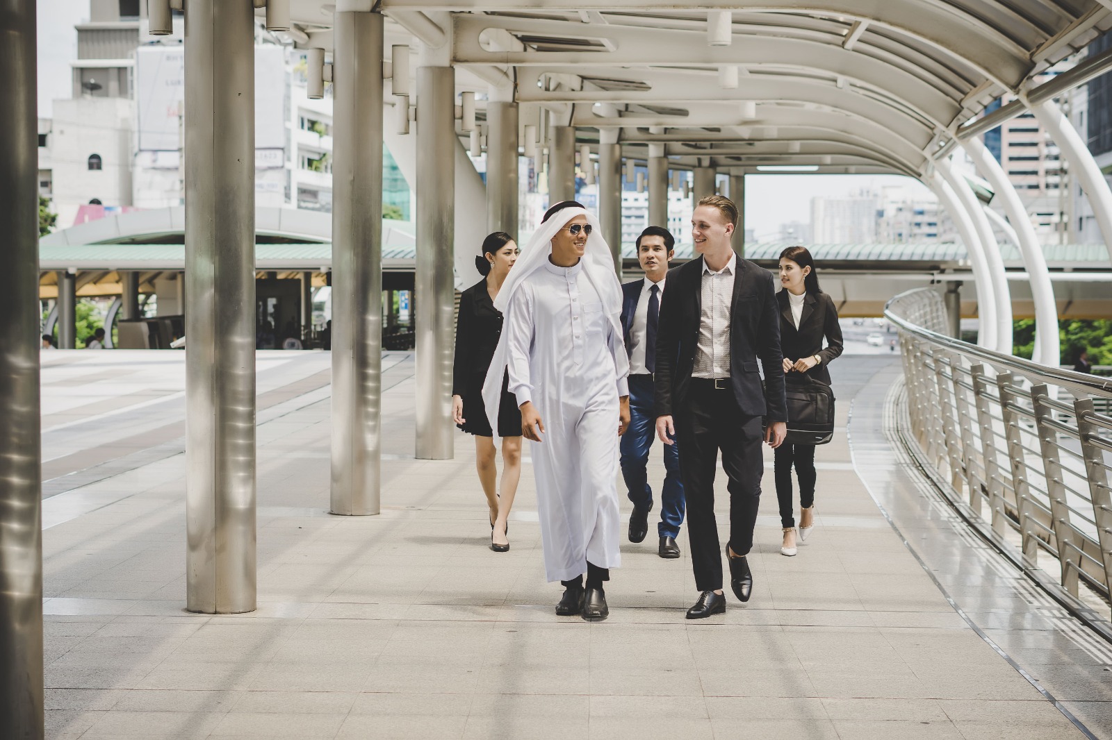 A group of Arab businessmen stroll on a bridge in a mainland business district to set up their business on the mainland..